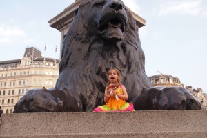 Lily on top of one of the Trafalgar Square lions after seeing The Lion King musical performance. She's even holding her toy Simba.